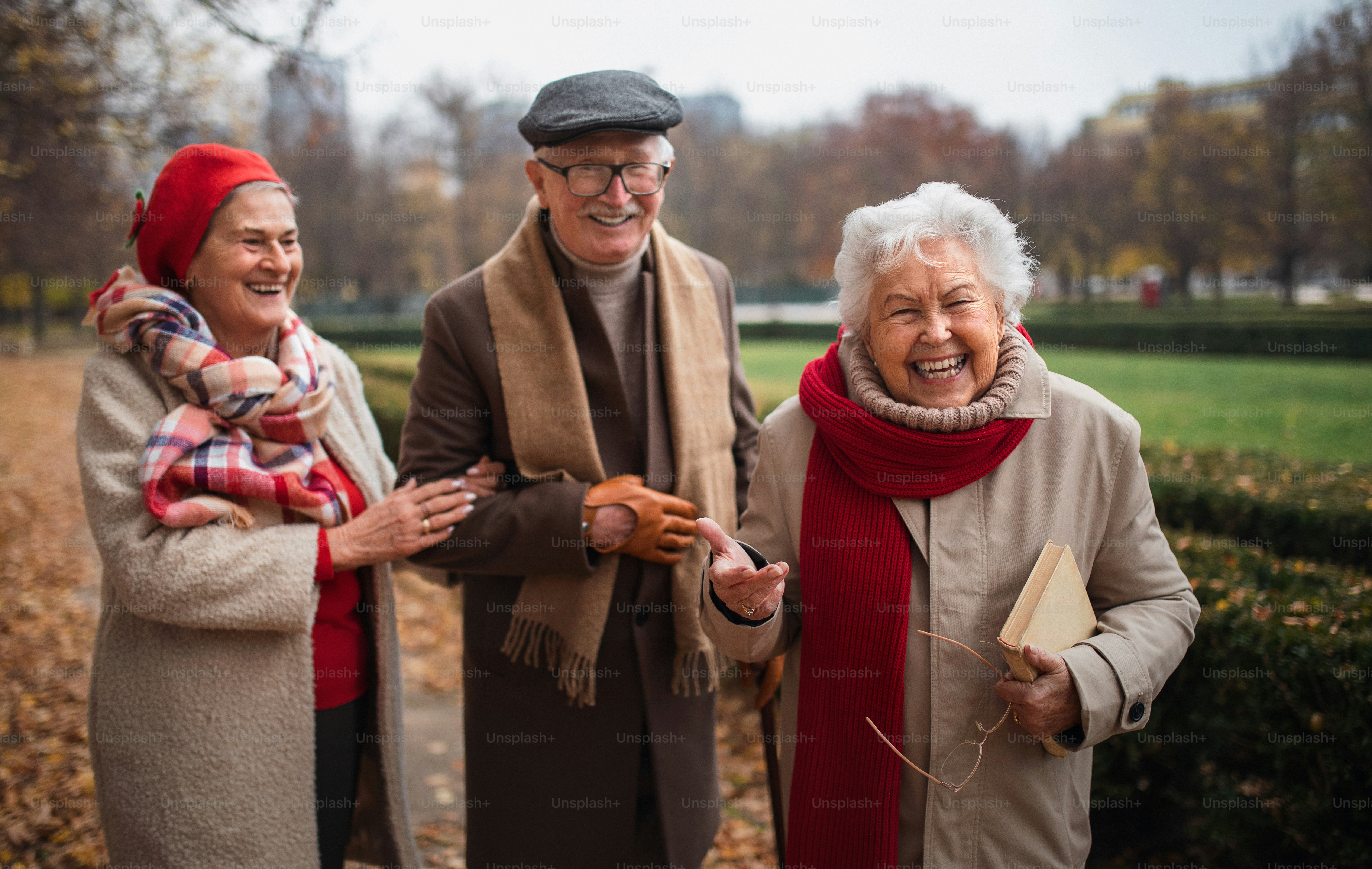 Un grupo de amigos mayores felices en un paseo al aire libre en el parque de la ciudad en otoño, mirando a la cámara.