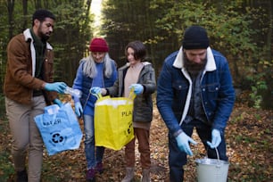 A diverse group of volunteers cleaning up forest from waste, community service concept
