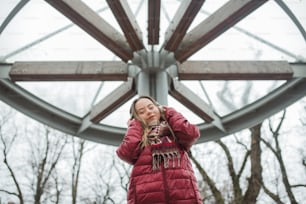 A happy young woman with Down syndrome listening to music in town in winter