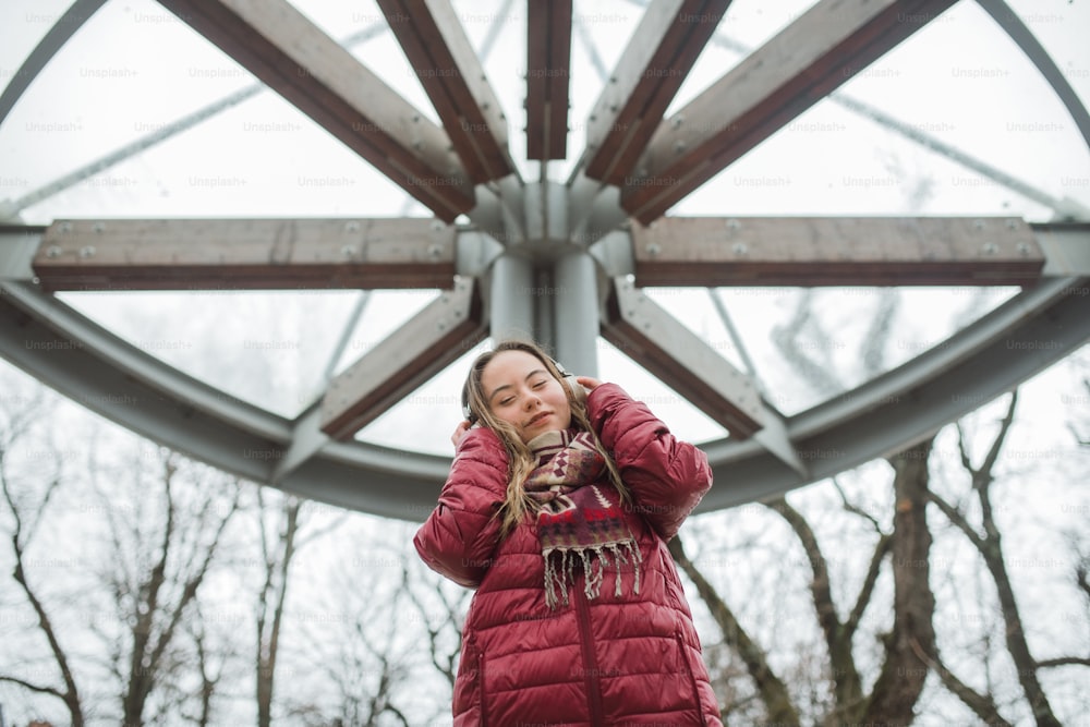 Une jeune femme trisomique heureuse écoutant de la musique en ville en hiver