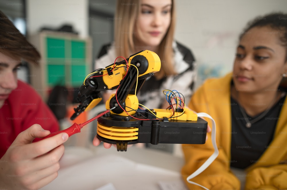 Eine Gruppe von Schülern, die elektrisches Spielzeug und Roboter im Robotik-Klassenzimmer bauen und programmieren