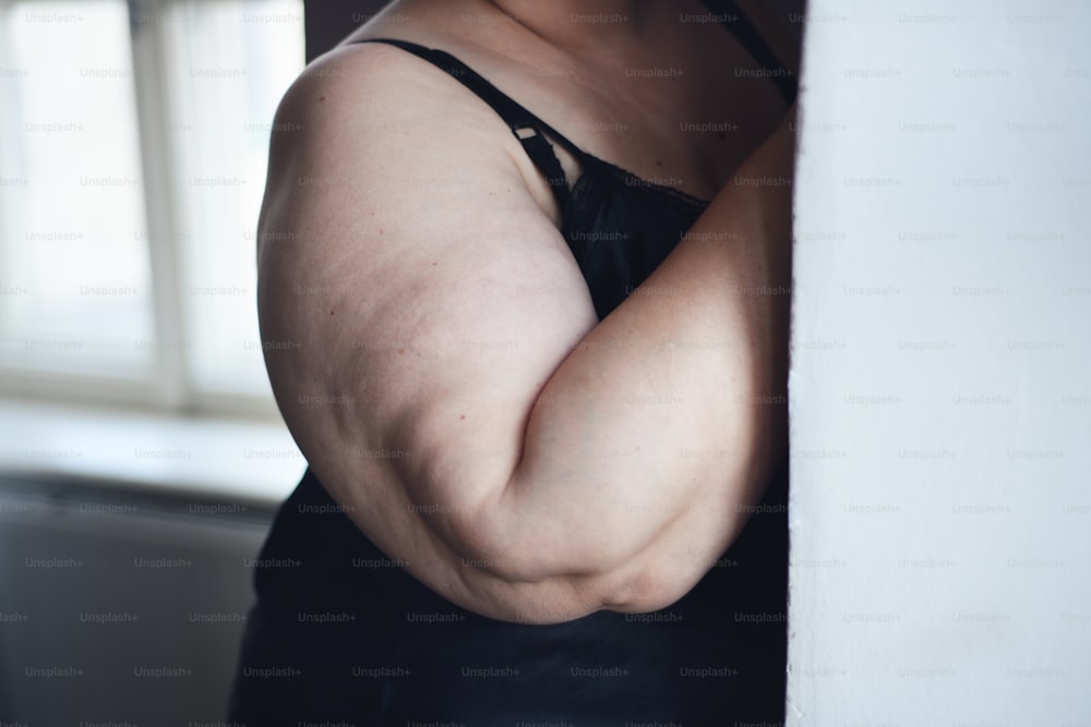 Un corte de mujer gorda solitaria en ropa interior en casa.