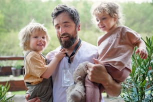 Glücklicher Vater Arzt endlich zu Hause Treffen mit seinen kleinen Kindern, Ende des Coronavirus.