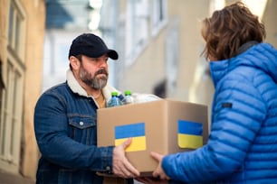 Volunteers collecting boxes with Humanitarian aid for the Ukrainian immigrants in street.