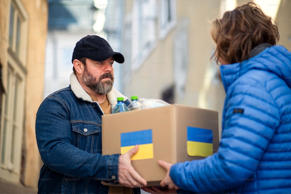 거리에서 우크라이나 이민자들을 위한 인도적 지원이 담긴 상자를 모으는 자원 봉사자들.