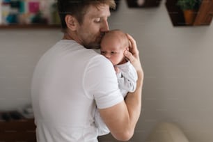 Ein Vater, der seinen neugeborenen Sohn zu Hause hält.