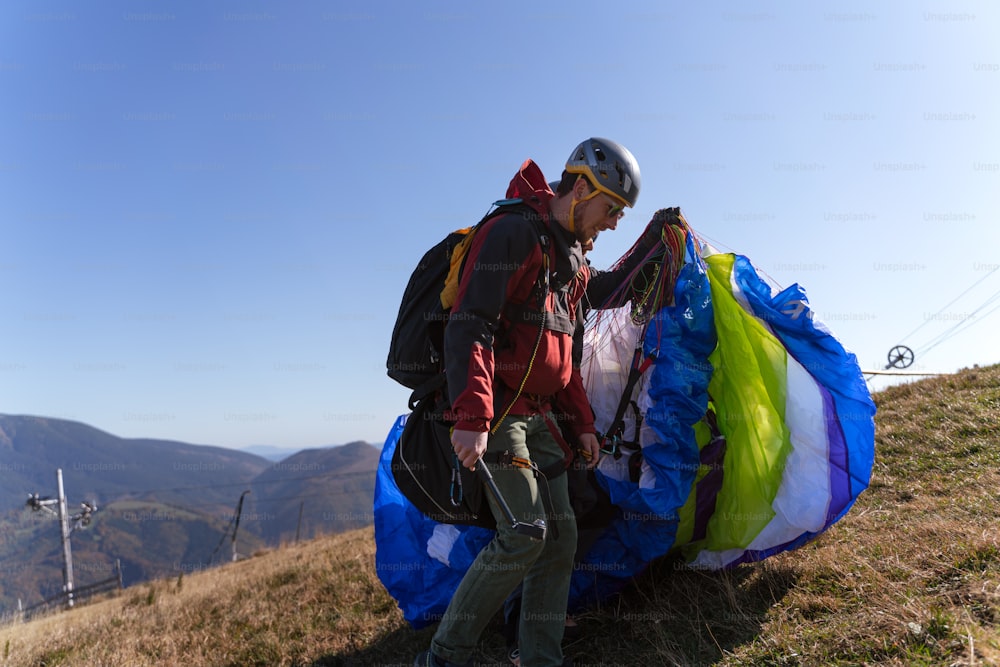 Parapentes preparándose para volar en montaña. Actividad deportiva extrema.