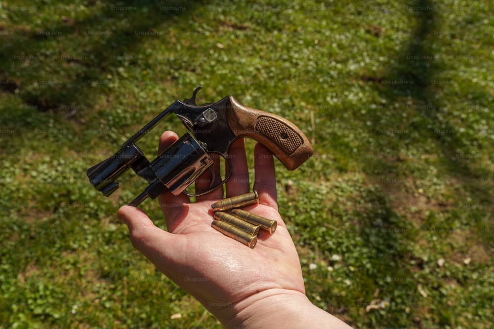 An unrecognizable man holding revolver with bullets in his hand, Close-up.