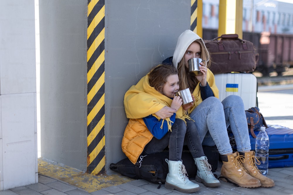 Depressed Ukrainian immigrants sitting and waiting at a railway station.