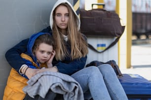 Immigrati ucraini depressi seduti e in attesa in una stazione ferroviaria.