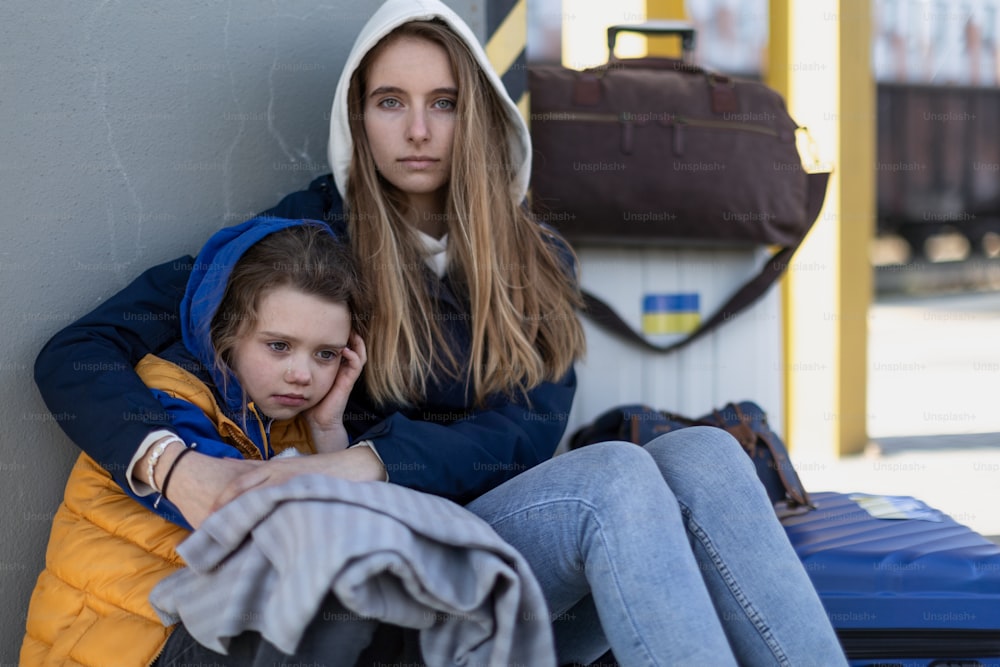 Depressed Ukrainian immigrants sitting and waiting at a railway station.