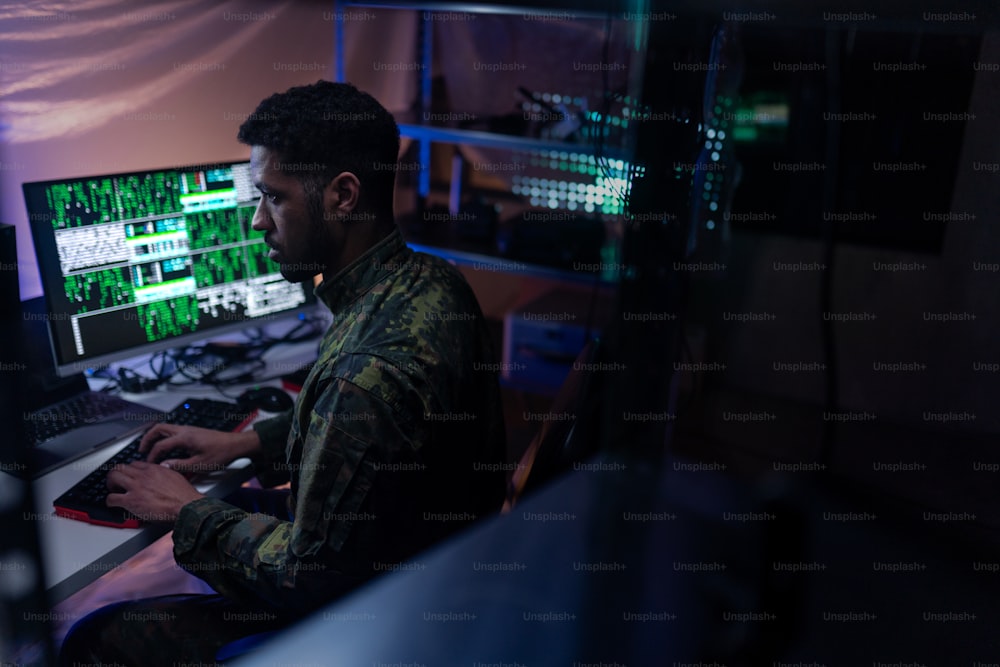 Un hacker in unifrorm militare sul dark web, concetto di guerra cibernetica.