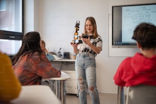 Young High school student is presenting her robotic project in a classroom