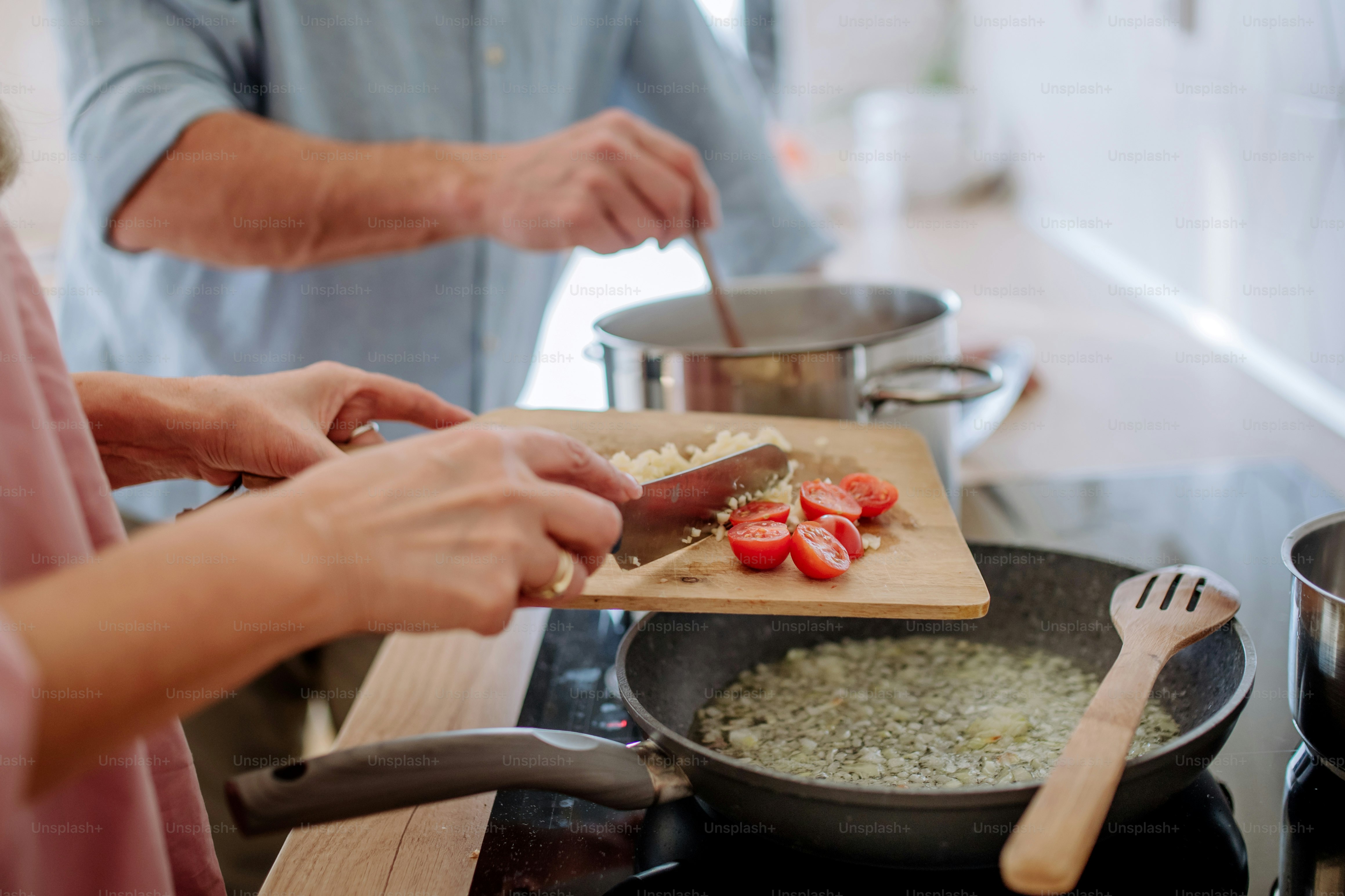 Una pareja de ancianos cocinando juntos en casa.
