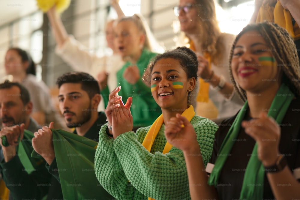 Jóvenes hermanas brasileñas hinchas de fútbol apoyando a su equipo en un estadio.