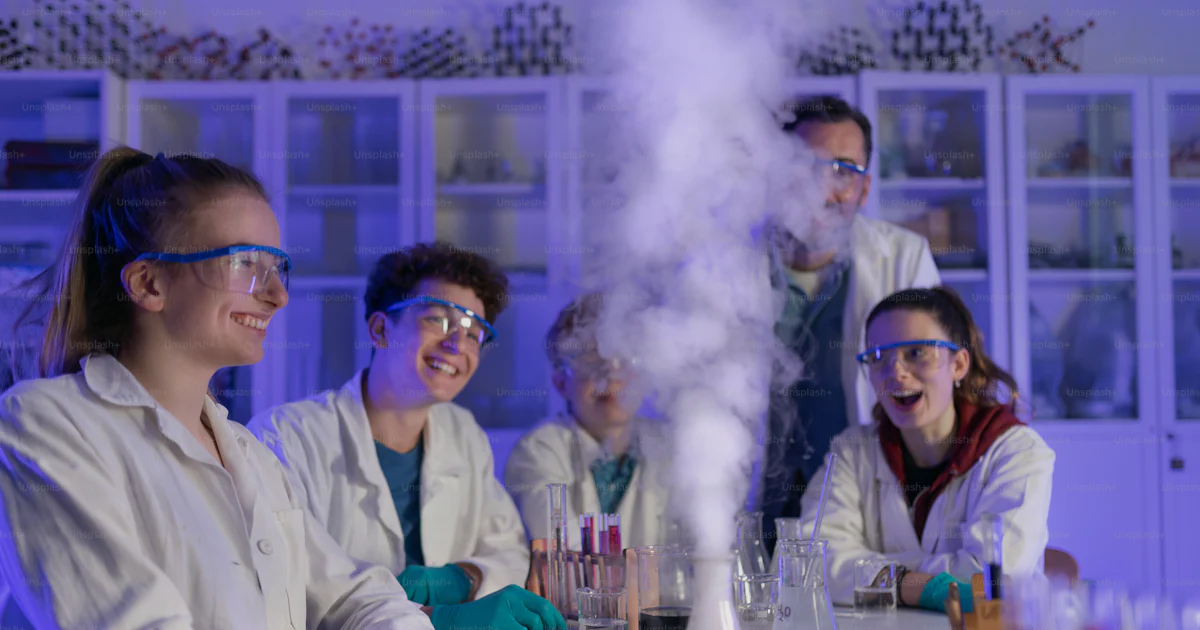 Freshman Experiments Science students doing a chemical experiment in the laboratory at ...