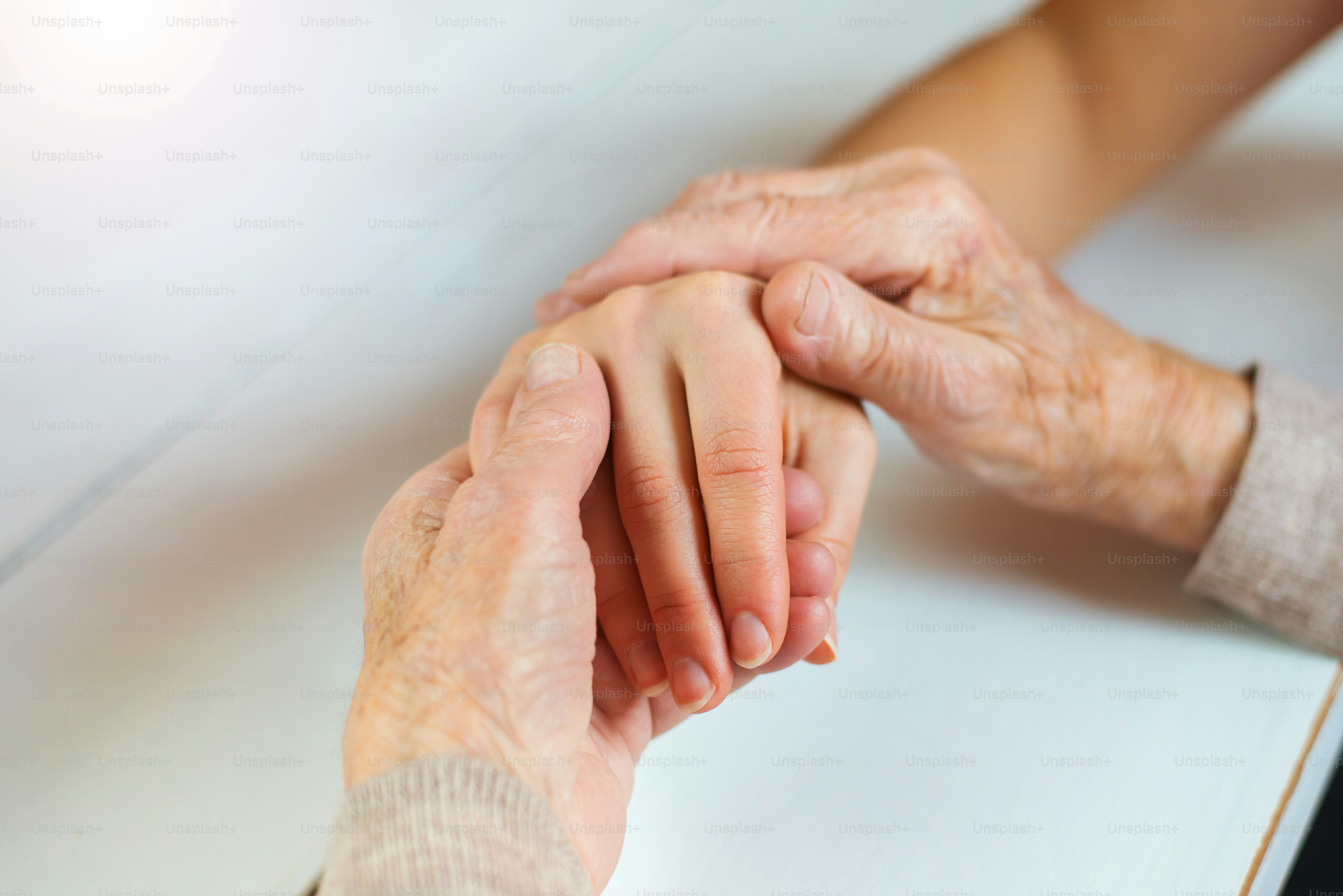 Unrecognizable grandmother and her granddaughter holding hands.