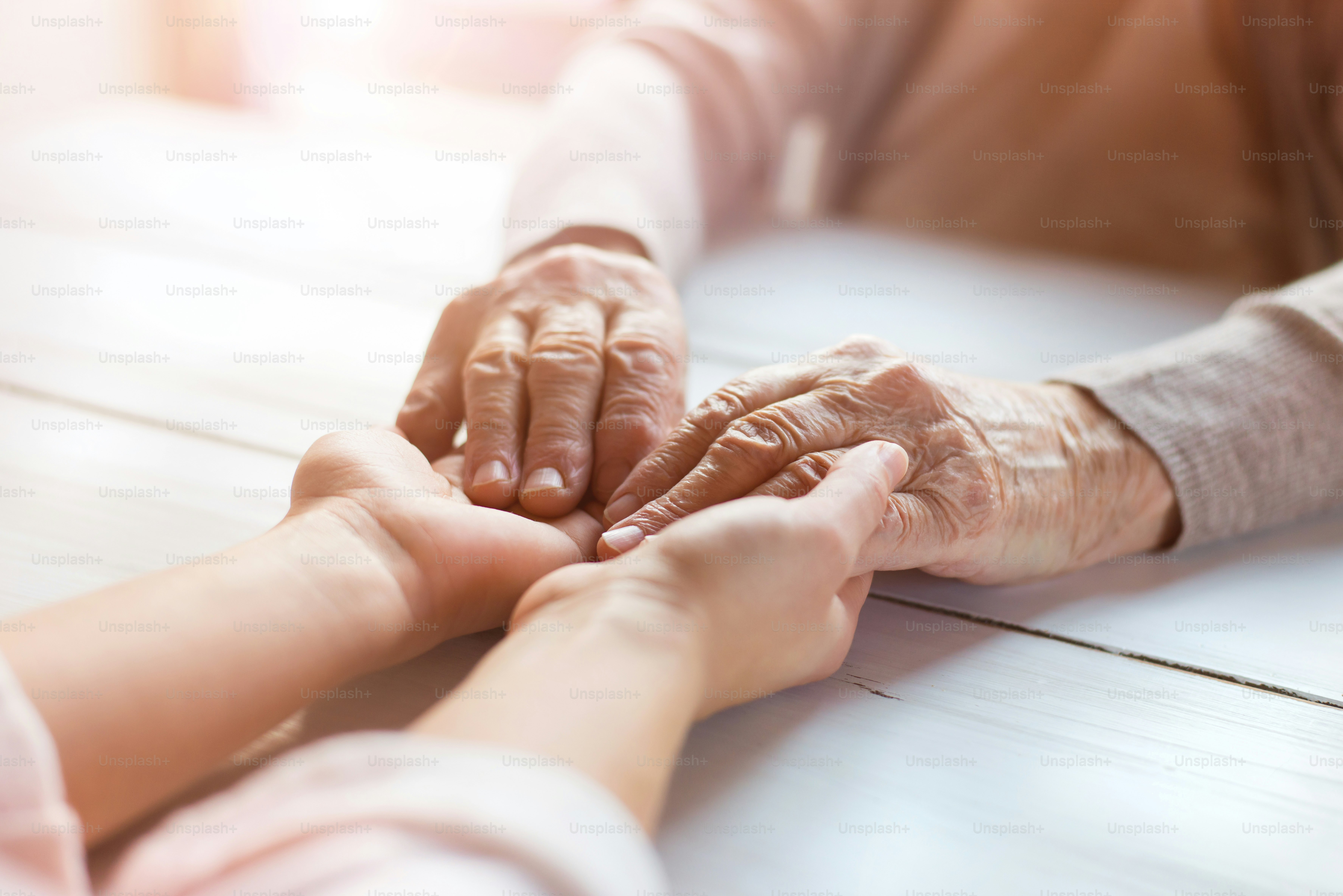 Unrecognizable grandmother and her granddaughter holding hands.