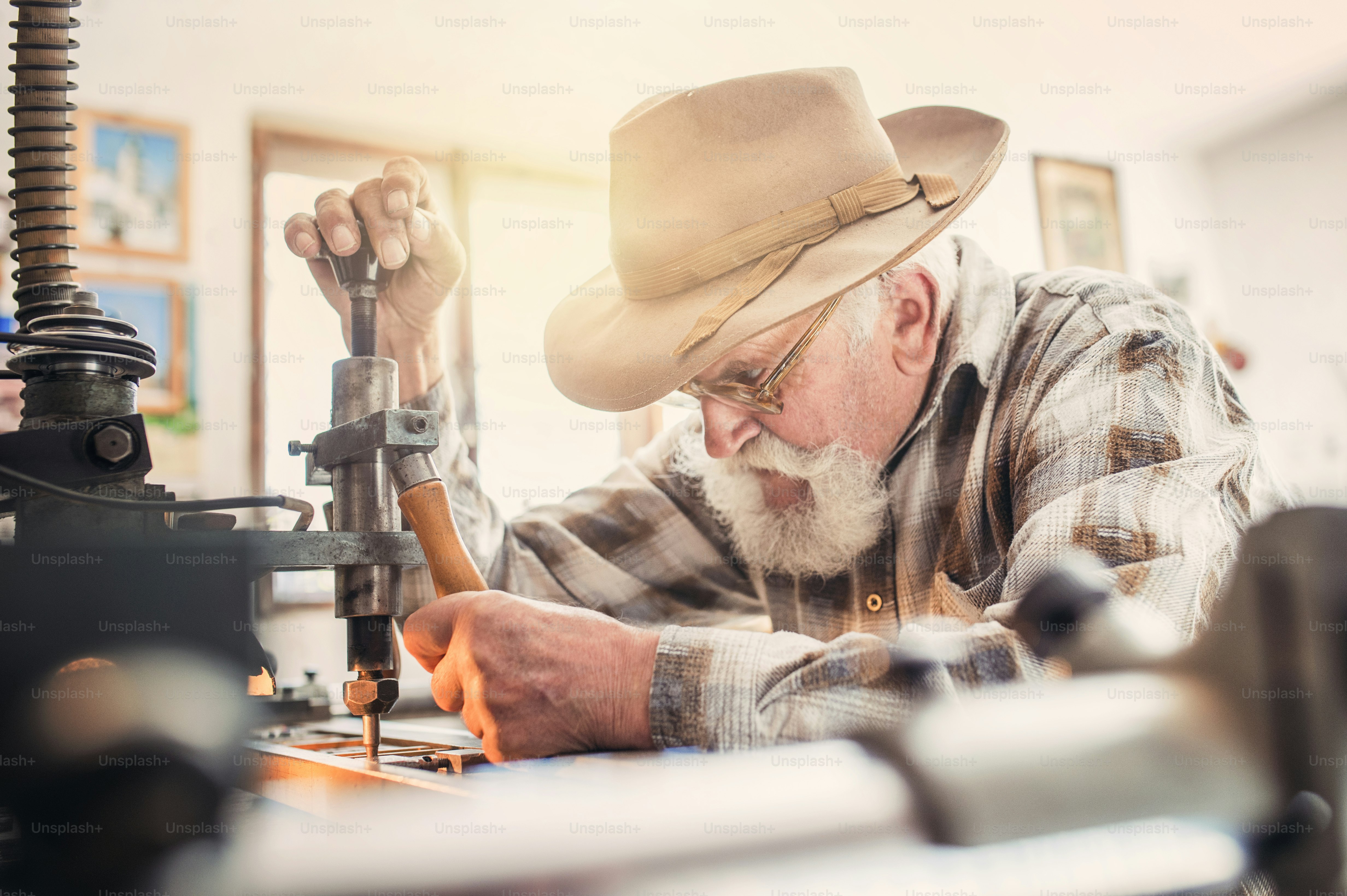 Senior man carving letters into marble plaque
