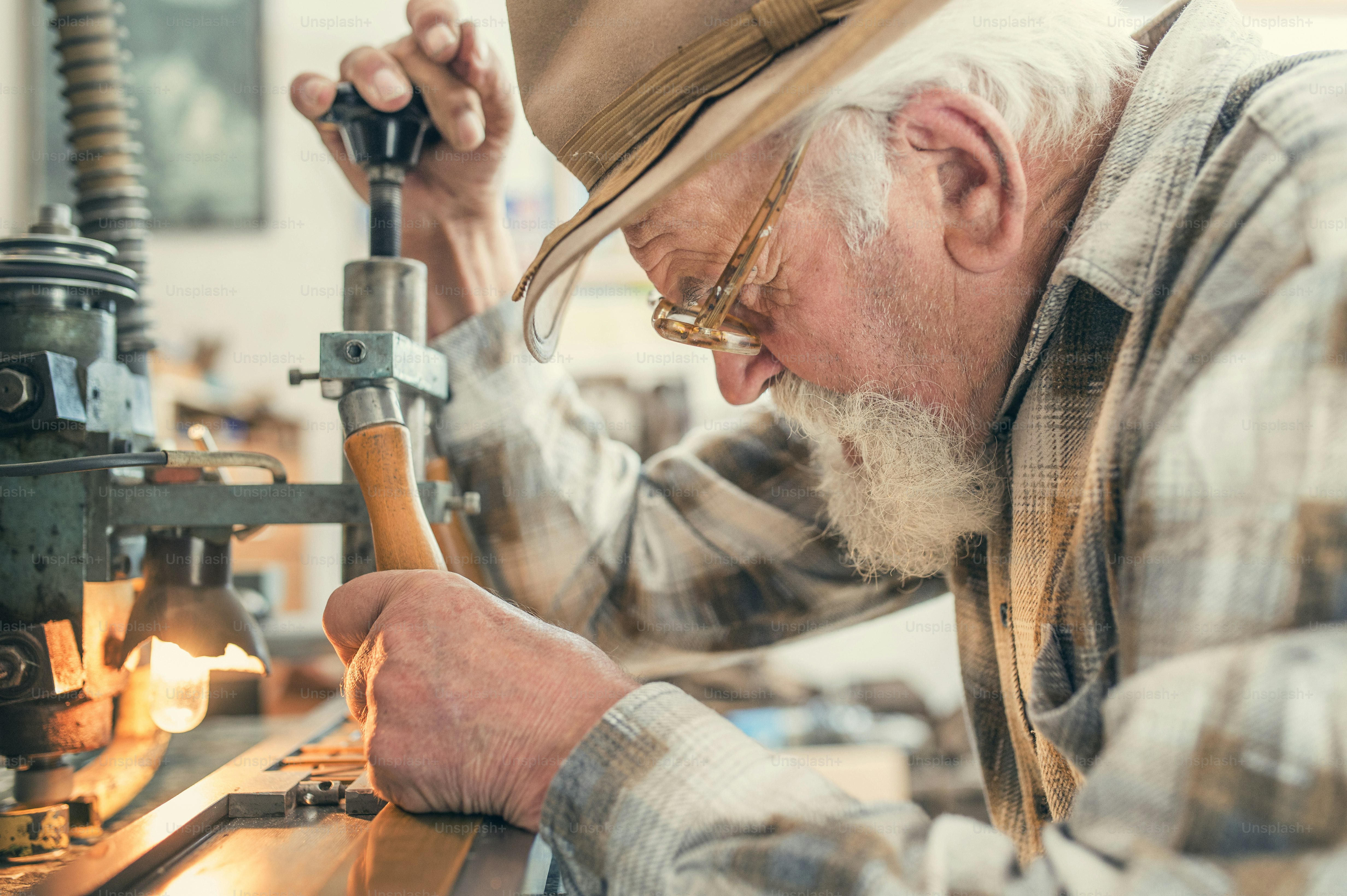 An old workshop filled with brass gears and antique clocks, warm golden light falling on an elderly clockmaker at his wooden workbench, intimate and cinematic