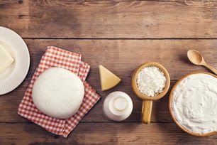 Variety of dairy products laid on a wooden table background