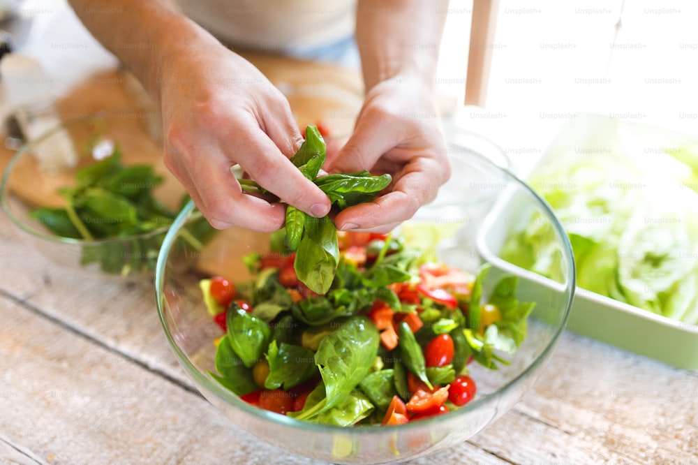 Homme méconnaissable préparant des ingrédients pour une salade de légumes