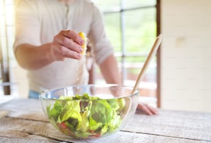 Unrecognizable man preparing ingredients for vegetable salad