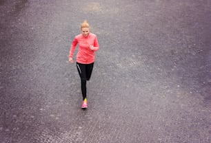 Beautiful young woman running in the city competition