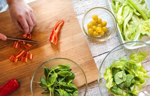 Unrecognizable man preparing ingredients for vegetable salad
