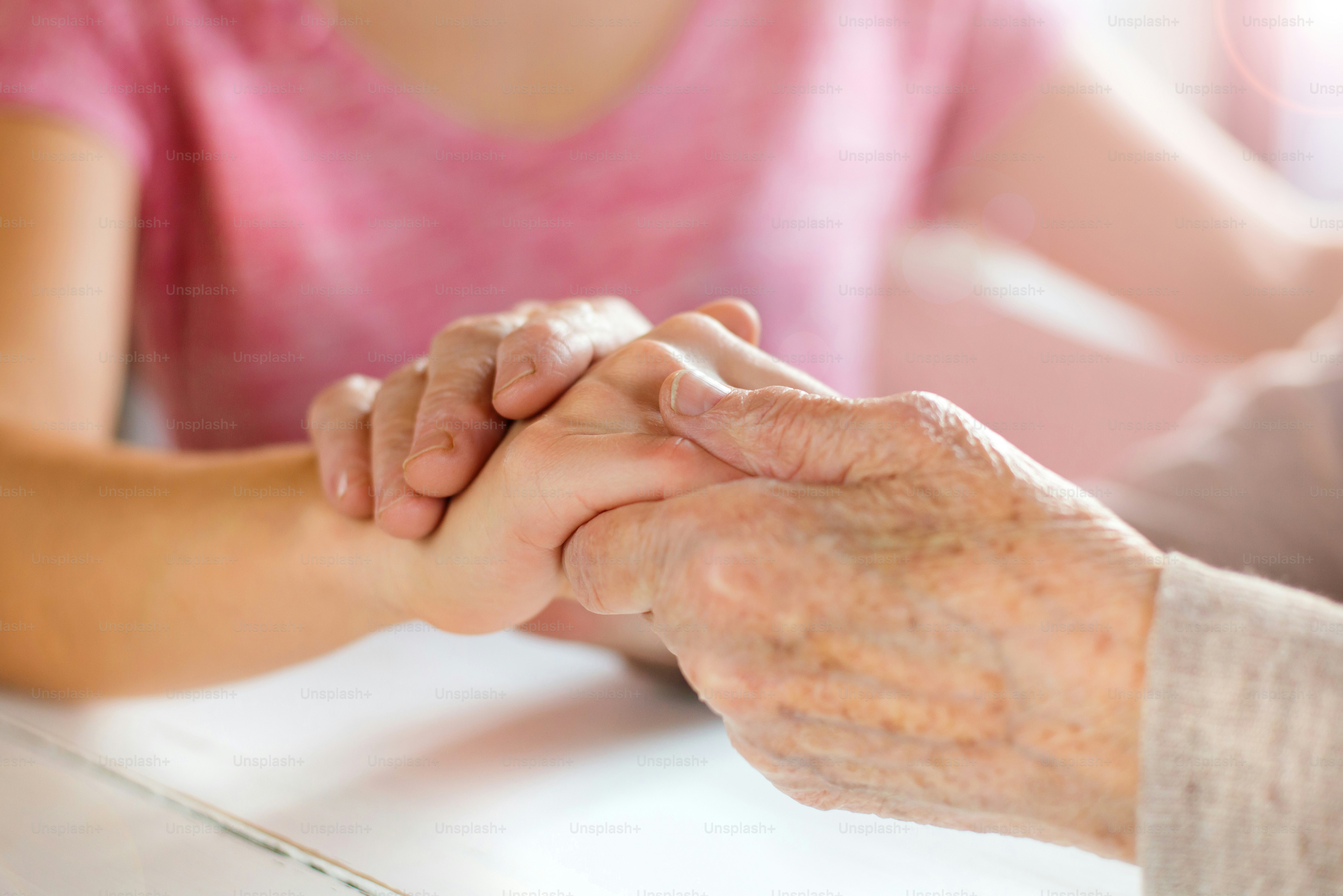 Unrecognizable grandmother and her granddaughter holding hands.