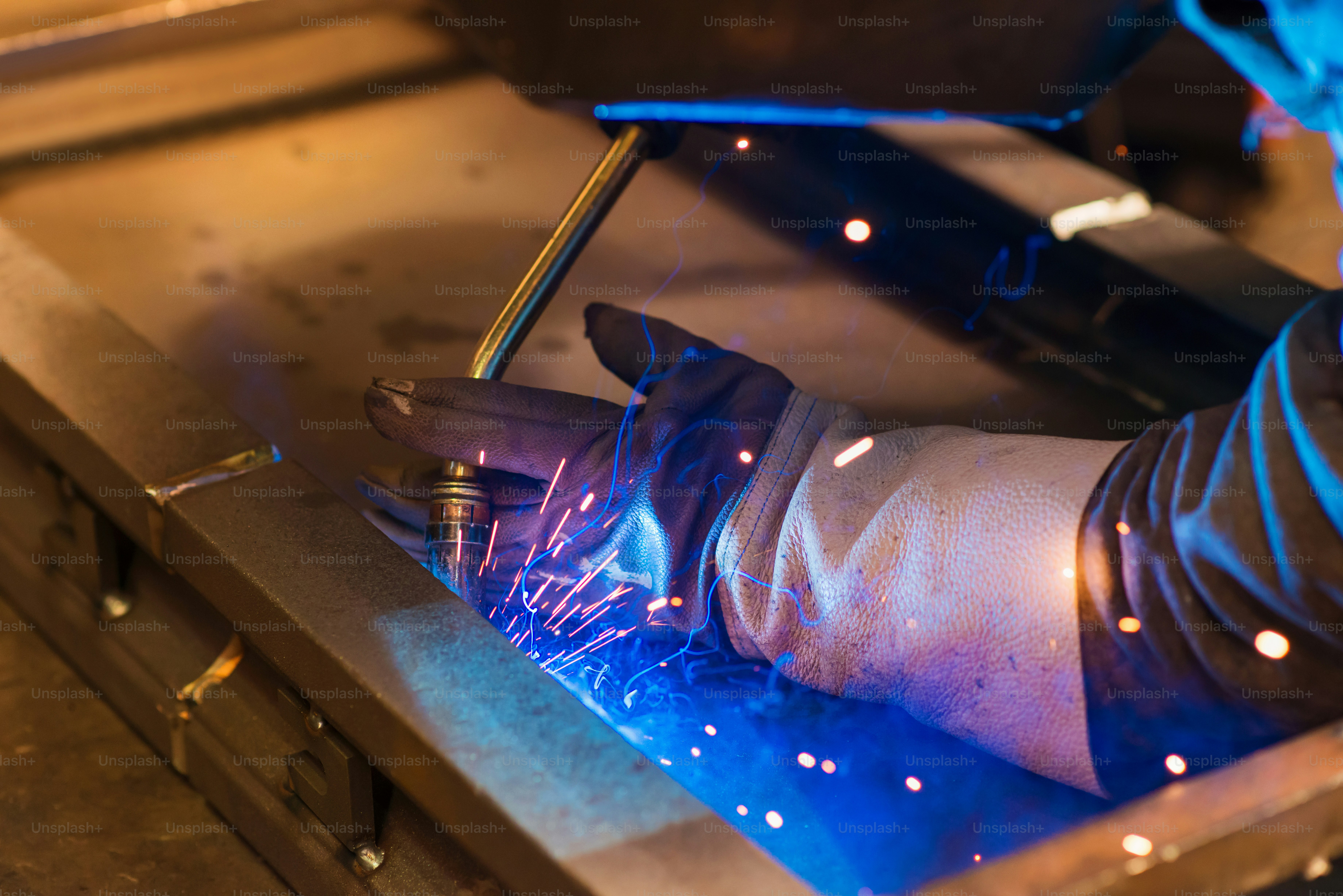 Unrecognizable young man welding in a factory