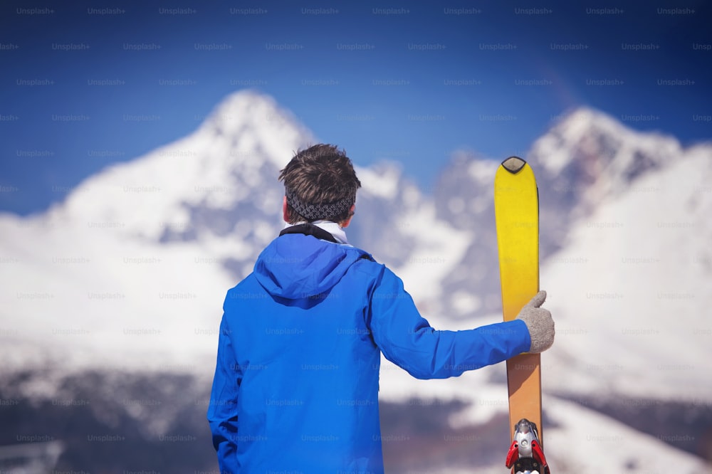 Young man skiing outside in sunny winter mountains