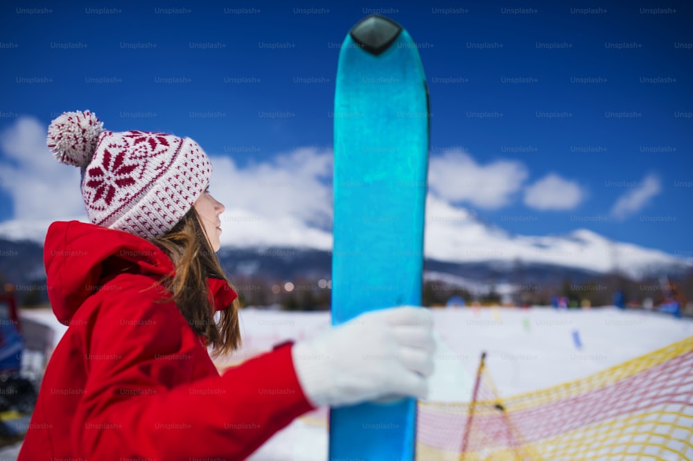 Giovane donna che scia fuori nelle montagne soleggiate di inverno