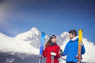 Jeune couple skiant à l’extérieur dans les montagnes ensoleillées d’hiver