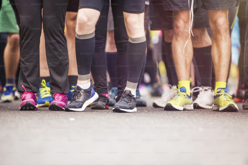 Detalhe das pernas dos corredores no início de uma corrida de maratona