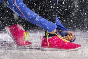 Athlete woman is running during winter training outside in cold snow weather.