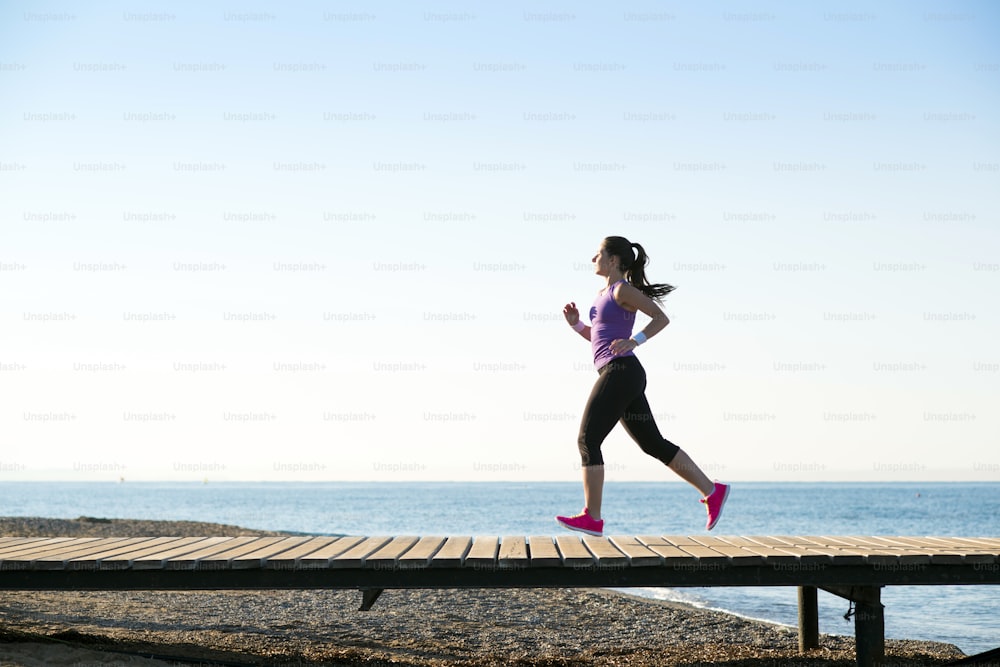 Young woman is running in sunny nature