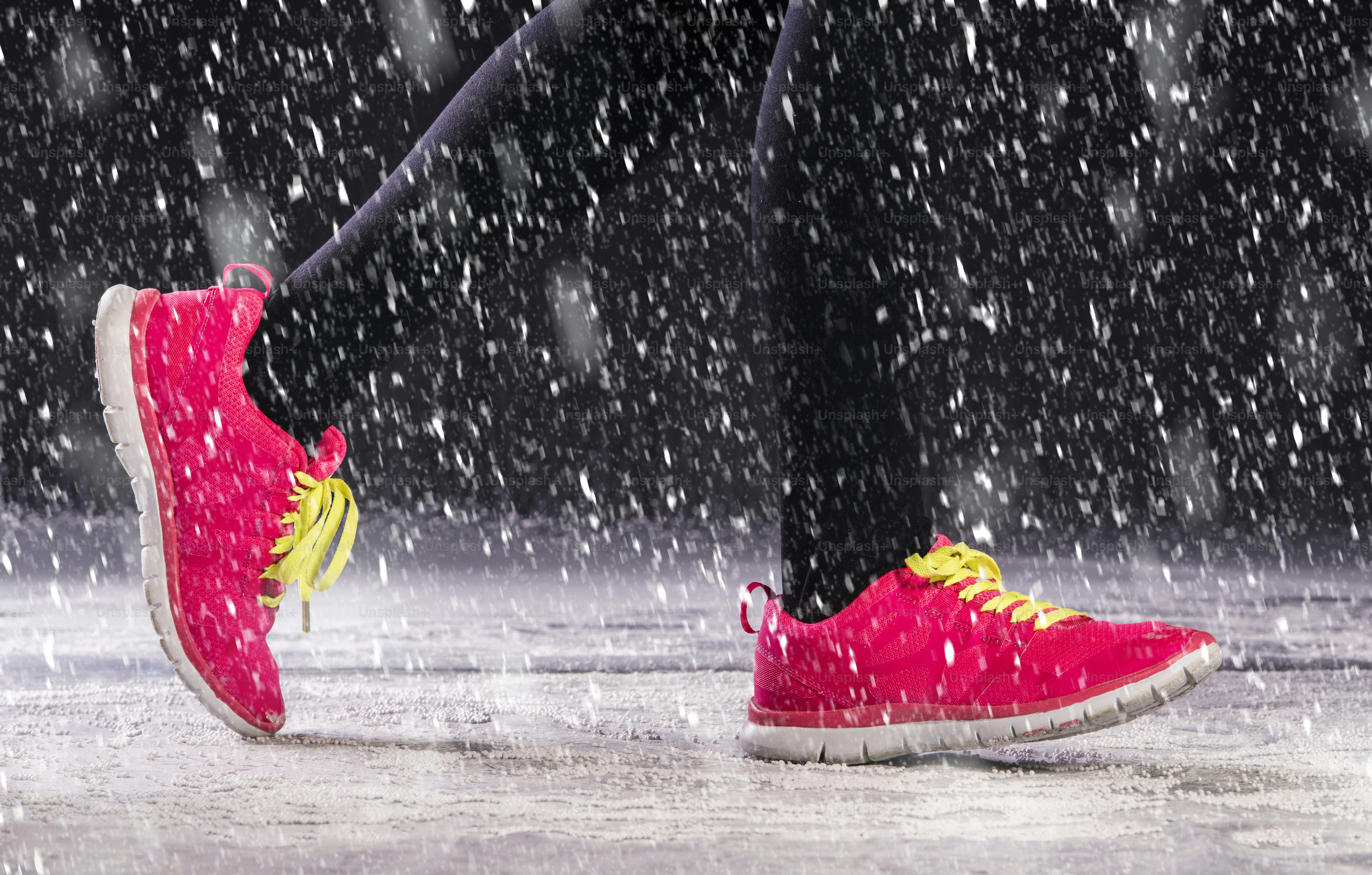 Athlete woman is running during winter training outside in cold snow ...