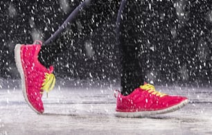 Athlete woman is running during winter training outside in cold snow weather.