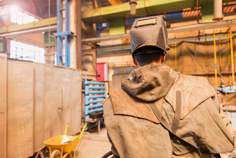 Young man in a welding factory in protective workwear