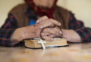Detail einer sehr alten Frau mit Kopftuch beim Beten