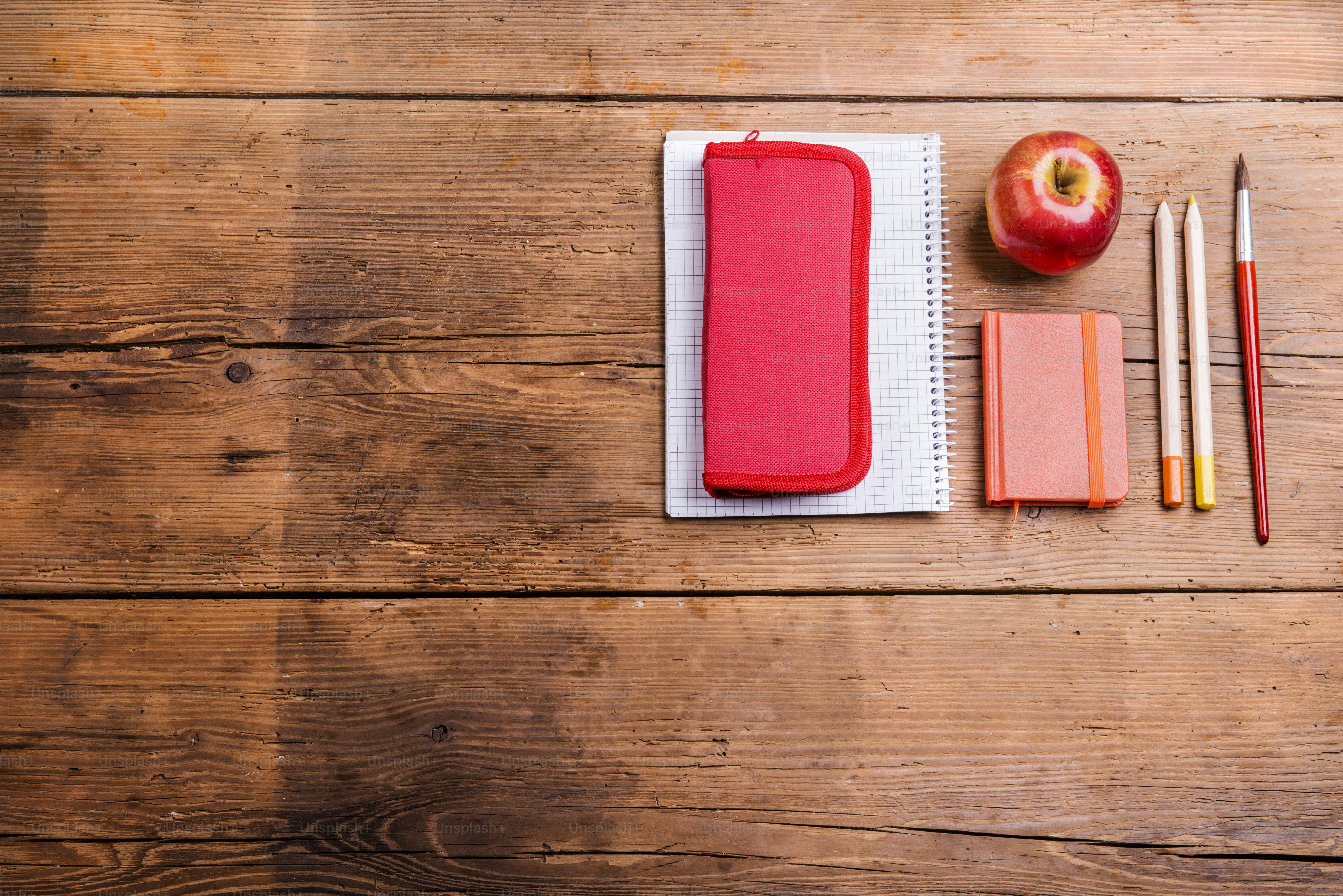 Desk with school supplies. Studio shot on wooden background.