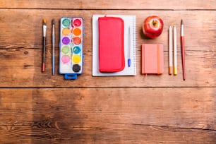 Desk with school supplies. Studio shot on wooden background.