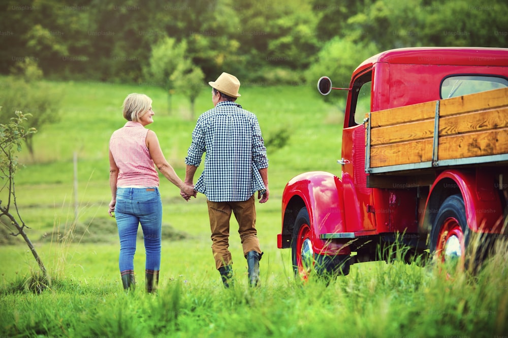 Senior couple walking by a red truck