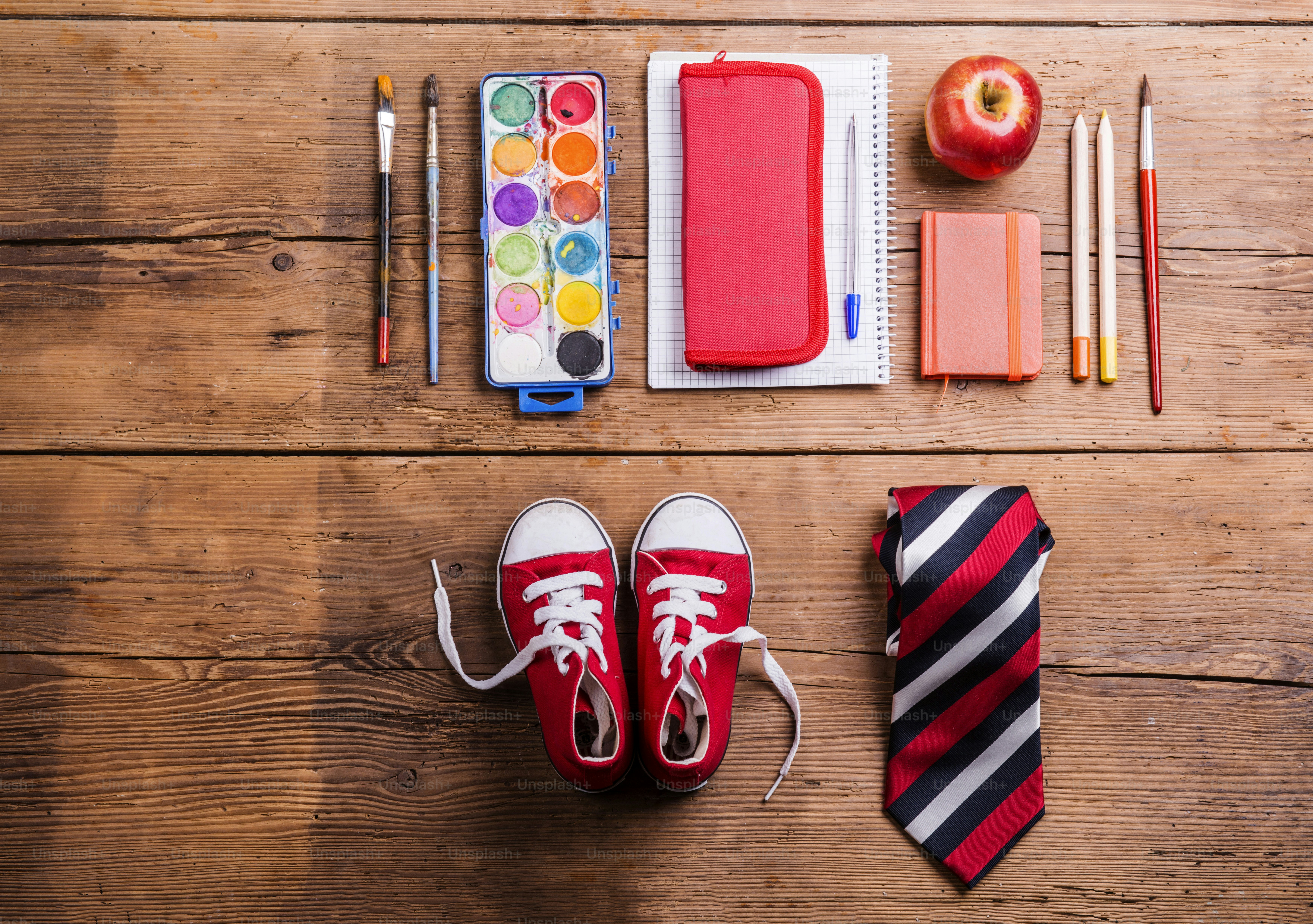 Desk with school supplies. Studio shot on wooden background.