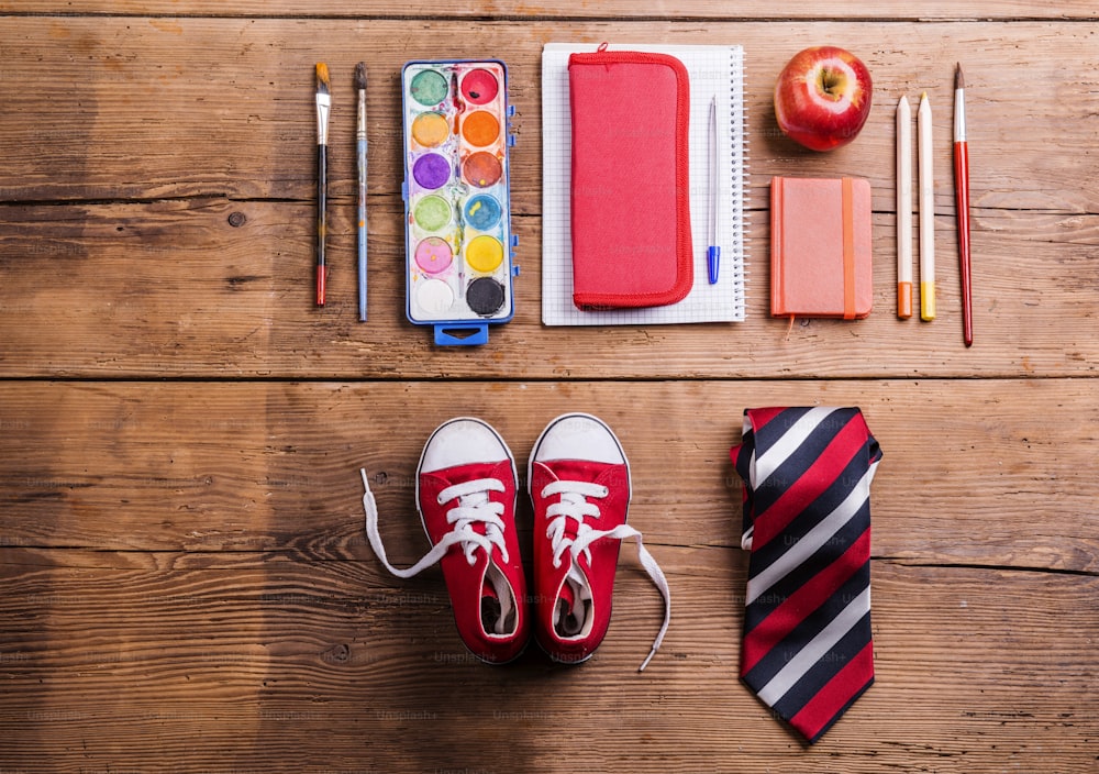 Desk with school supplies. Studio shot on wooden background.