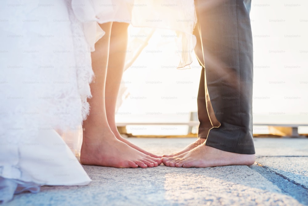 Feet of a bride and groom standing on the pier