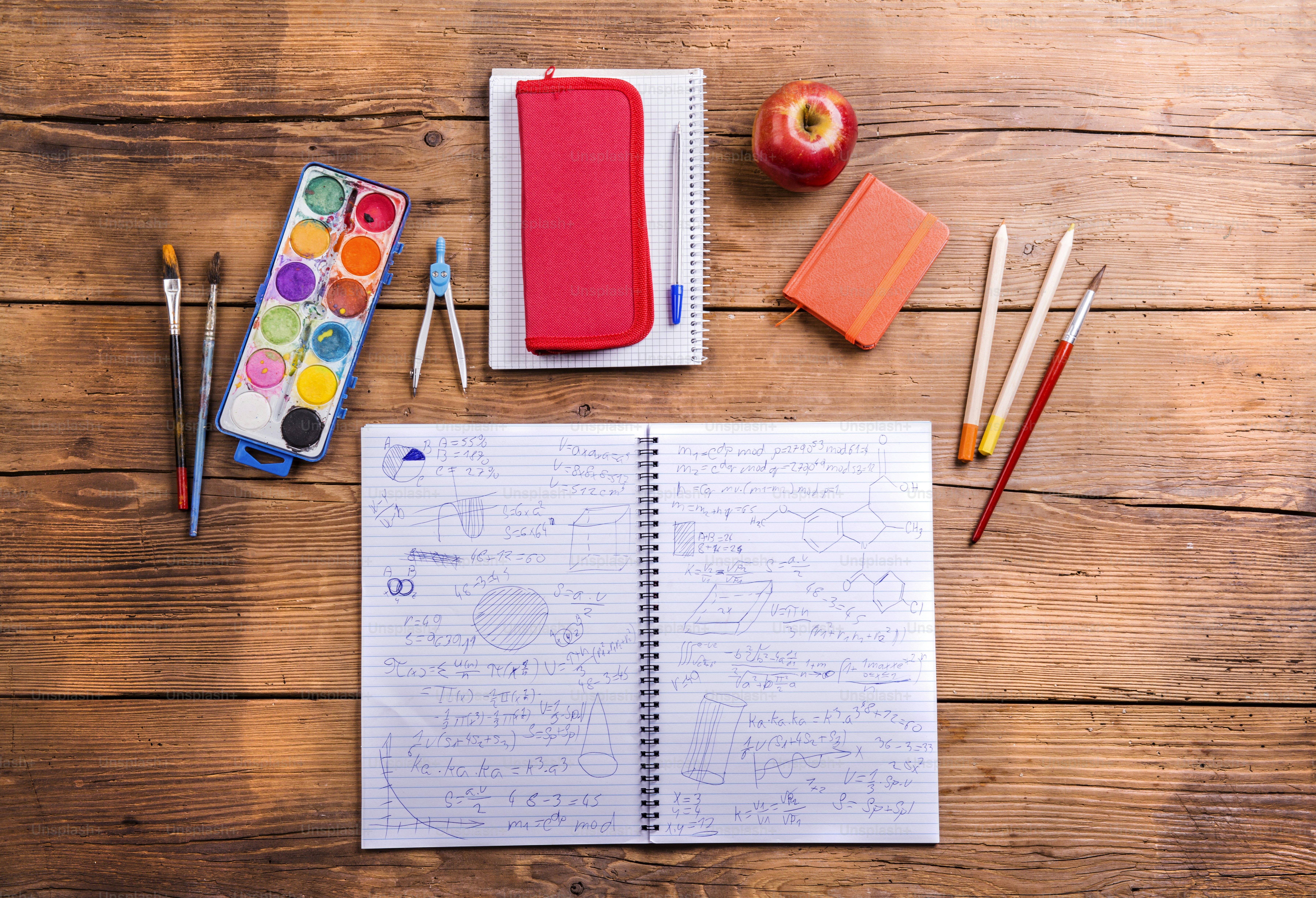 Desk with school supplies. Studio shot on wooden background.