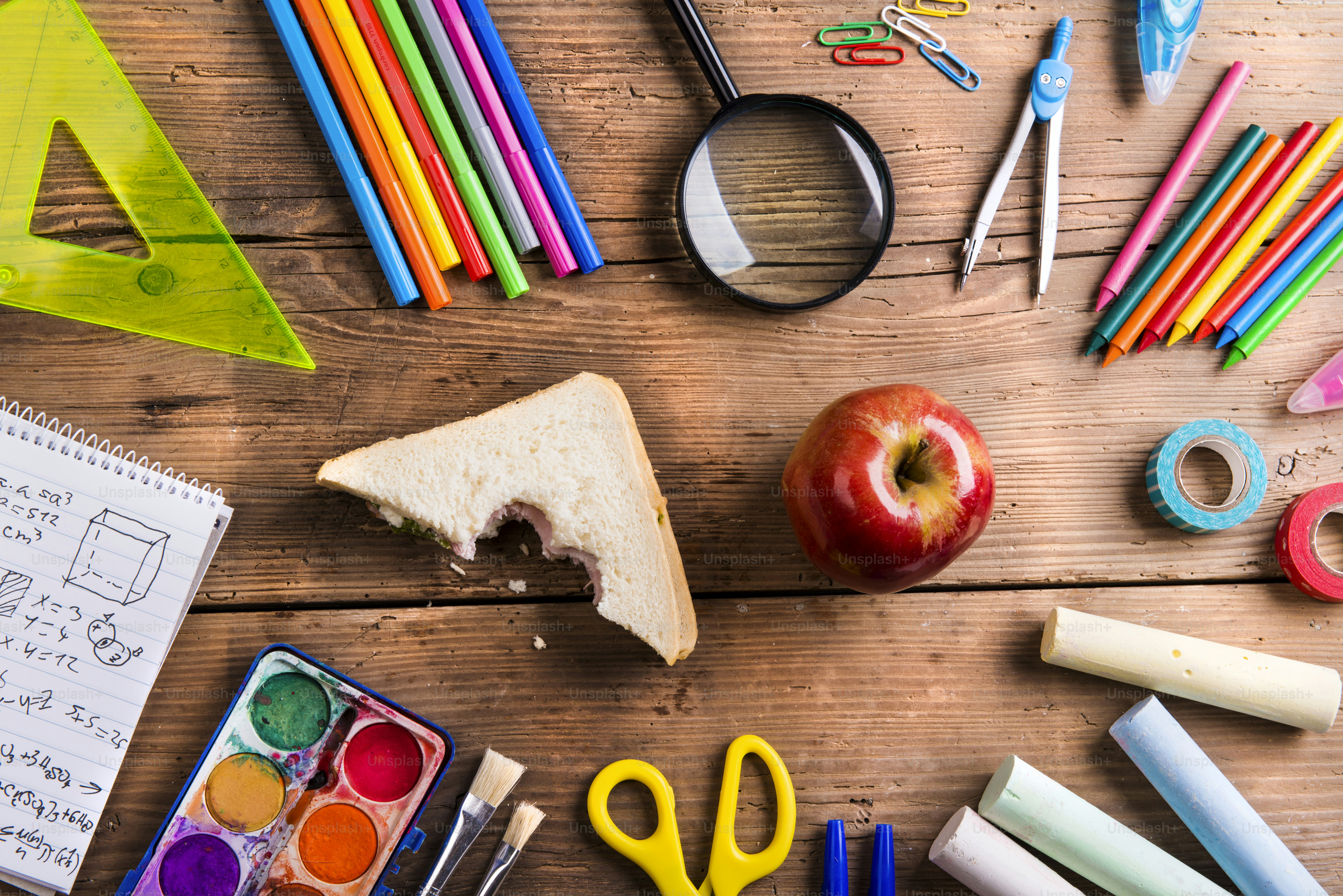 Desk with school supplies. Studio shot on wooden background.