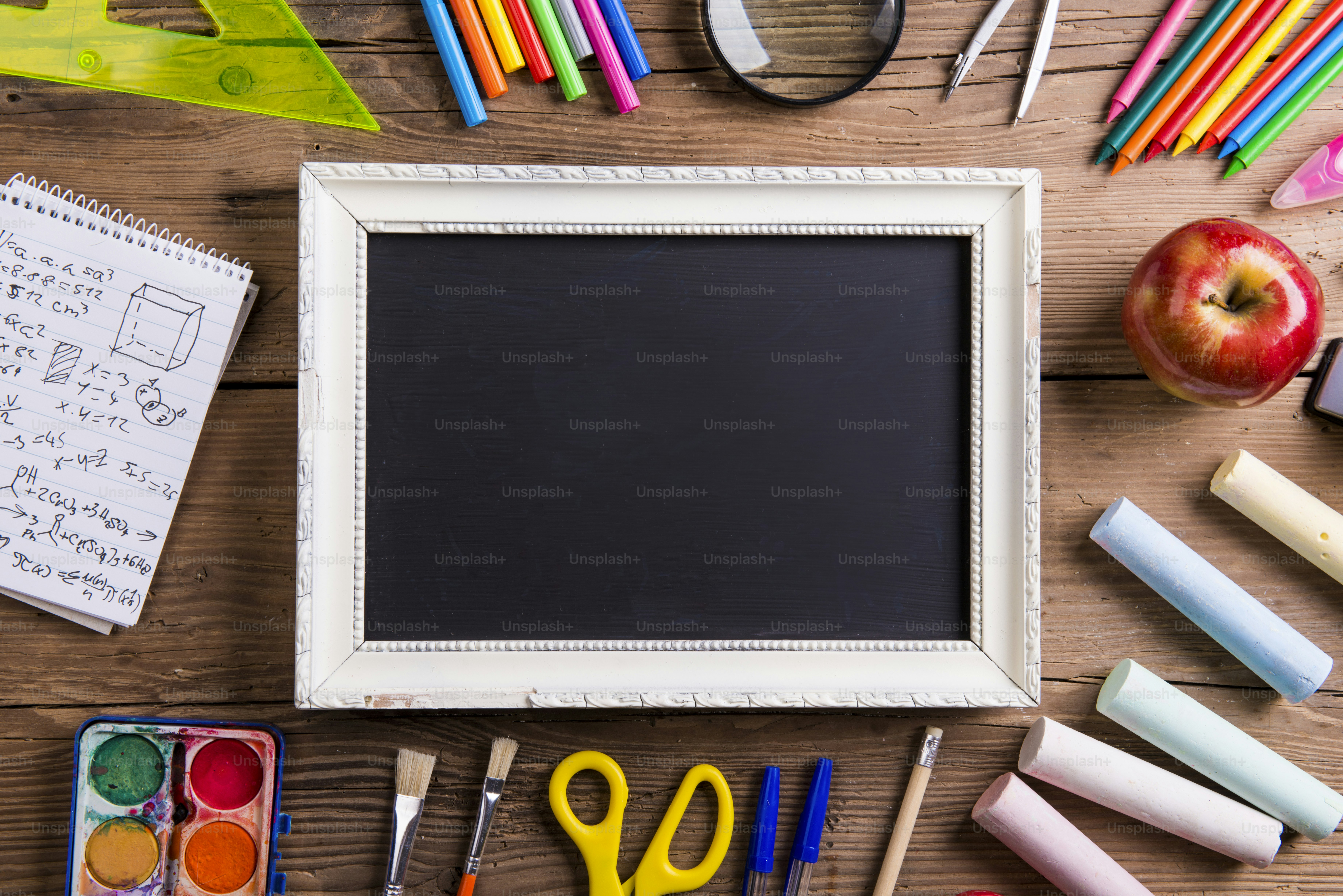Desk with school supplies. Studio shot on wooden background.